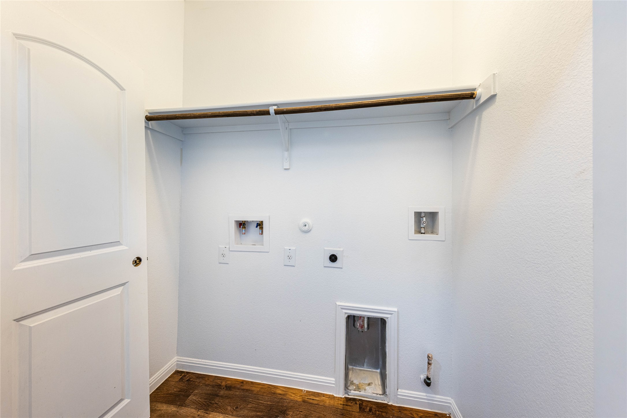 368 Wapiti Road Buda, TX 78610 - Photo 14 of 20 Dedicated laundry area featuring wood-finish flooring, white walls, and a built-in hanging rod with shelving