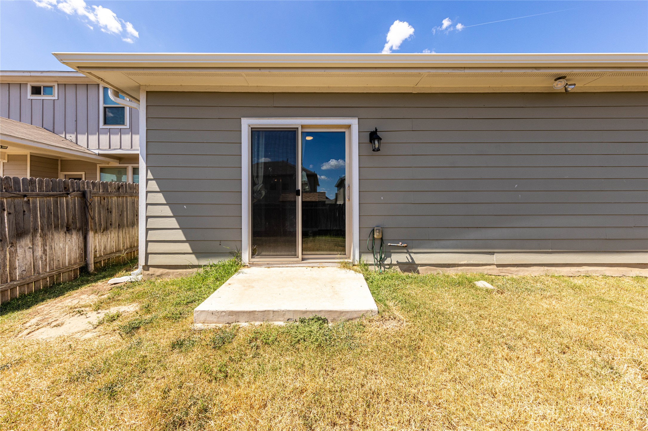 368 Wapiti Road Buda, TX 78610 - Photo 18 of 20 Rear exterior featuring gray horizontal siding and a sliding glass door