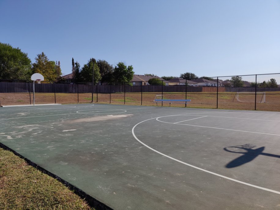 368 Wapiti Road Buda, TX 78610 - Photo 19 of 20 Outdoor sports court with a basketball hoop, white court lines, and a perimeter chain-link fence