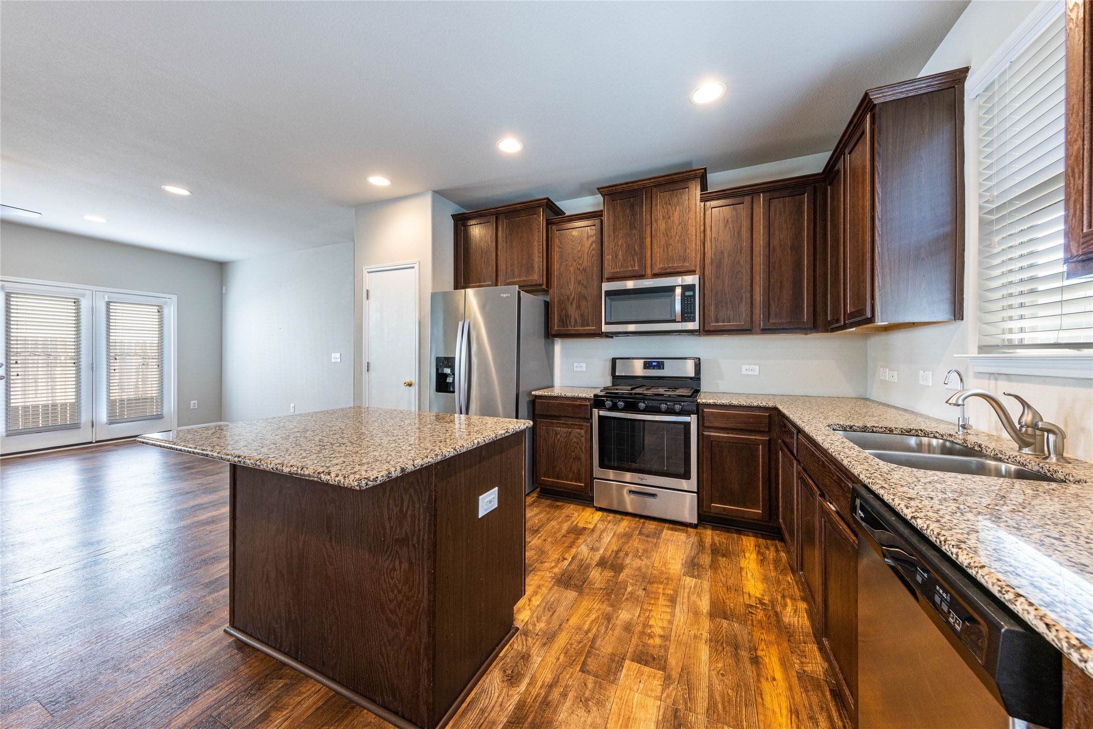 368 Wapiti Road Buda, TX 78610 - Photo 6 of 20 Kitchen featuring dark wood cabinetry, stainless steel appliances, granite countertops, and a central island