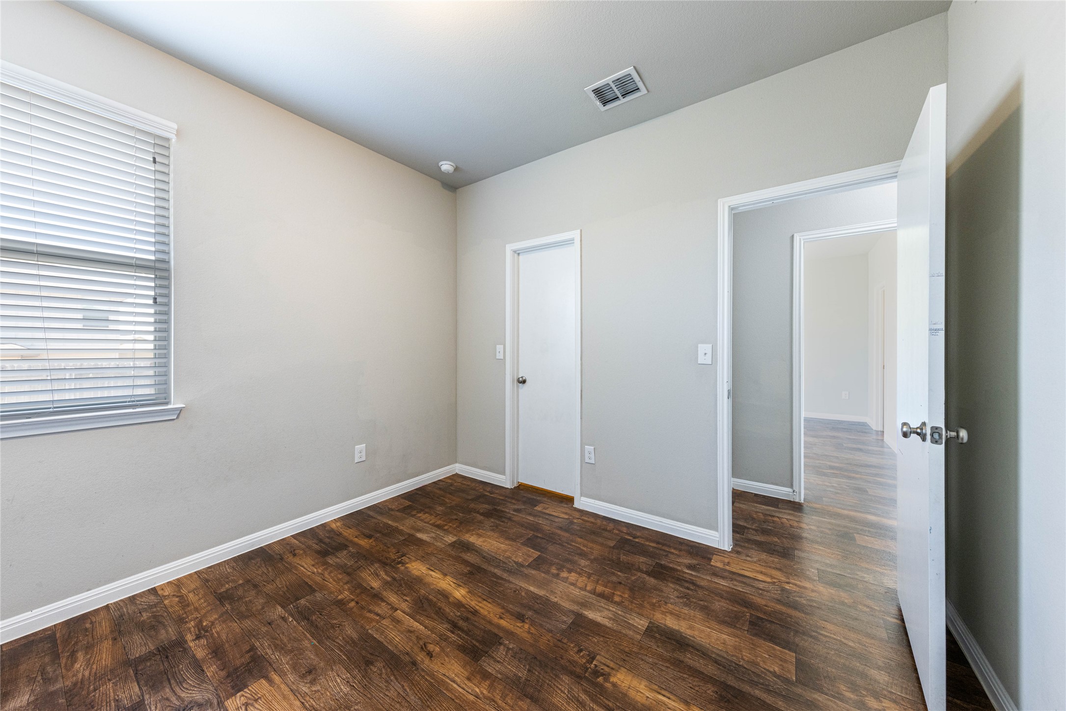 368 Wapiti Road Buda, TX 78610 - Photo 10 of 20 Room featuring wood-finish flooring, a window with horizontal blinds, and two white interior doors