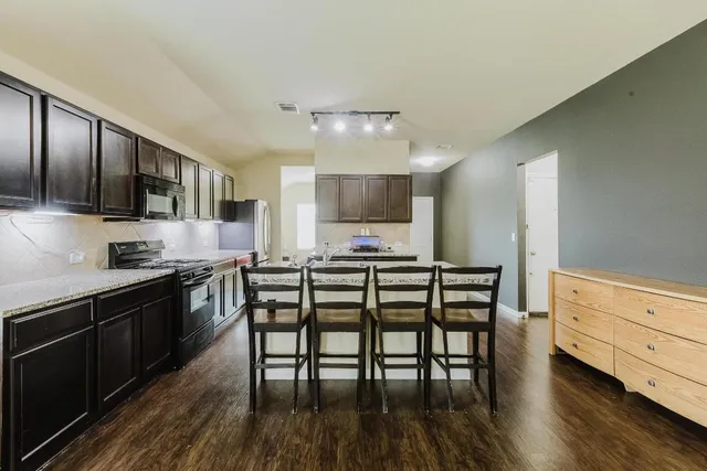 a kitchen with stainless steel appliances wooden floors and wooden cabinets