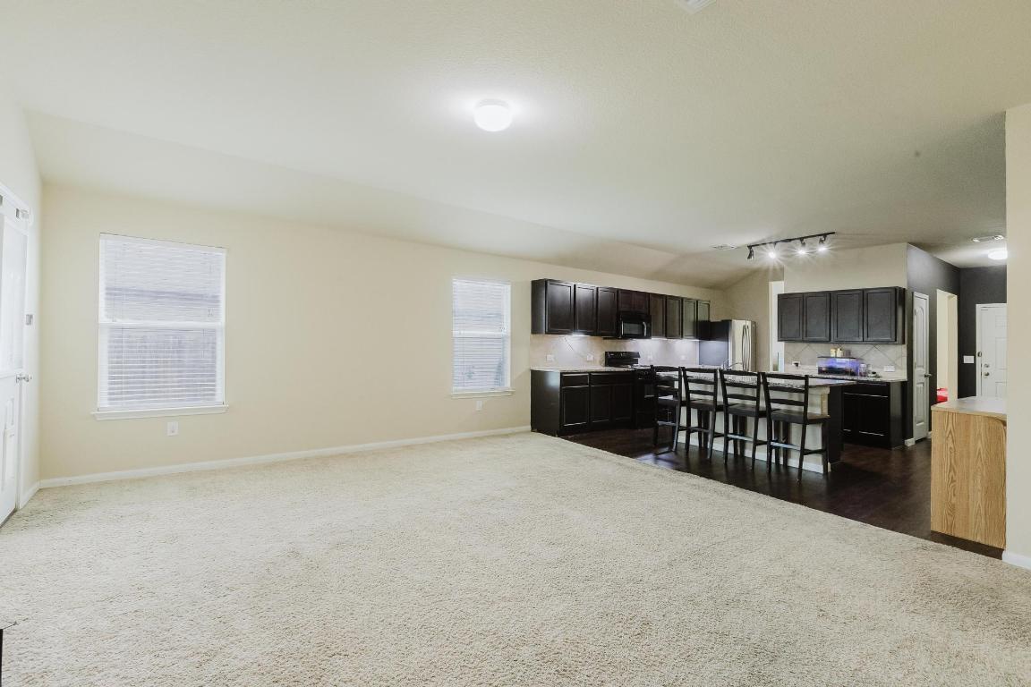 184 Voss Kyle, TX 78640 - Photo 14 of 30 a kitchen with stainless steel appliances kitchen island granite countertop a sink and cabinets