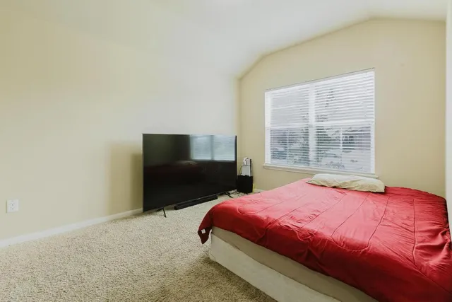 a bedroom with a bed and a window