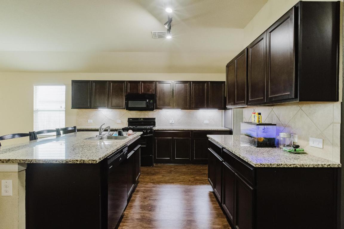 184 Voss Kyle, TX 78640 - Photo 10 of 30 a kitchen with stainless steel appliances granite countertop a stove a sink dishwasher and a refrigerator