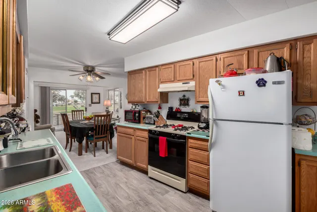 a kitchen with refrigerator a stove and a dining table