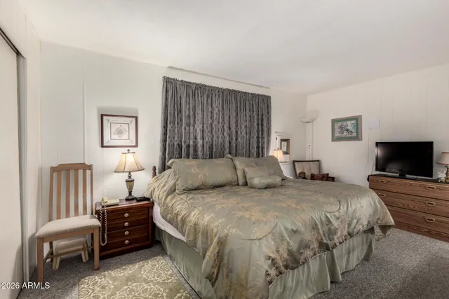 a bedroom with a bed and a flat screen tv