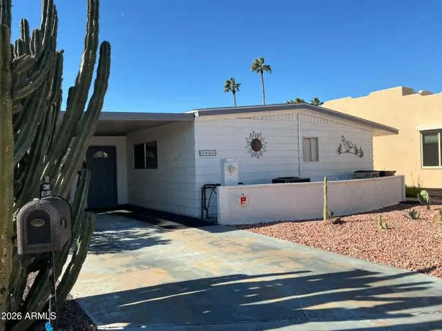 a bedroom with a bed and a potted plant on the table