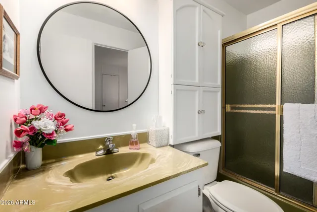 a bathroom with a sink mirror toilet and shower