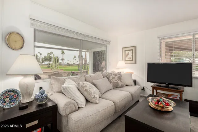 a living room with furniture a flat screen tv and a window