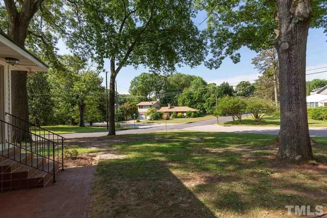 a view of a house with a yard and tree