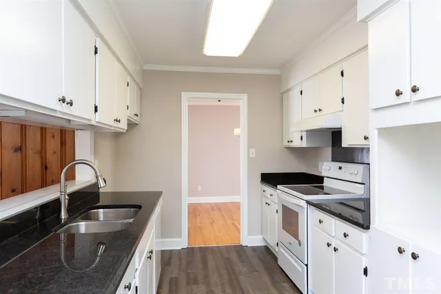 a kitchen with granite countertop a sink stainless steel appliances and cabinets