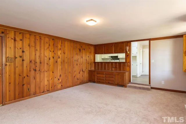 a view of an empty room with a fireplace and a window