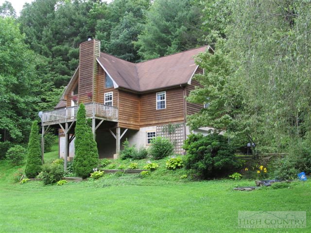 a aerial view of a house next to a big yard and large trees