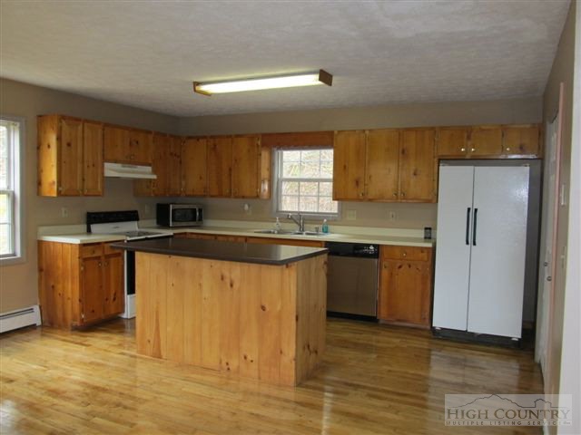 3192 Wildcat Road Deep Gap, NC 28618 - Photo 21 of 24 a kitchen with granite countertop a sink cabinets and stainless steel appliances