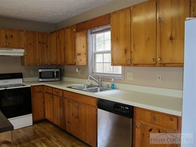 3192 Wildcat Road Deep Gap, NC 28618 - Photo 22 of 24 a kitchen with stainless steel appliances granite countertop a sink stove and cabinets