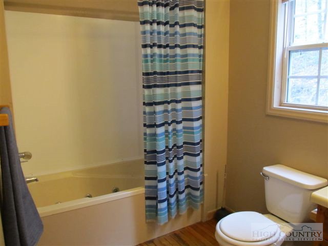 3192 Wildcat Road Deep Gap, NC 28618 - Photo 4 of 24 a bathroom with a toilet and a shower curtain