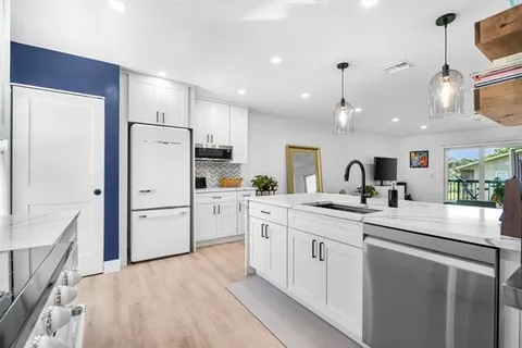 a kitchen with white cabinets and white appliances