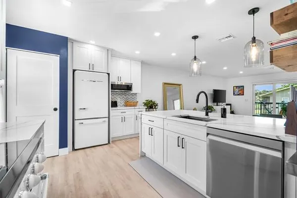 a kitchen with white cabinets and white appliances