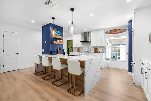 a large kitchen with a table and chairs