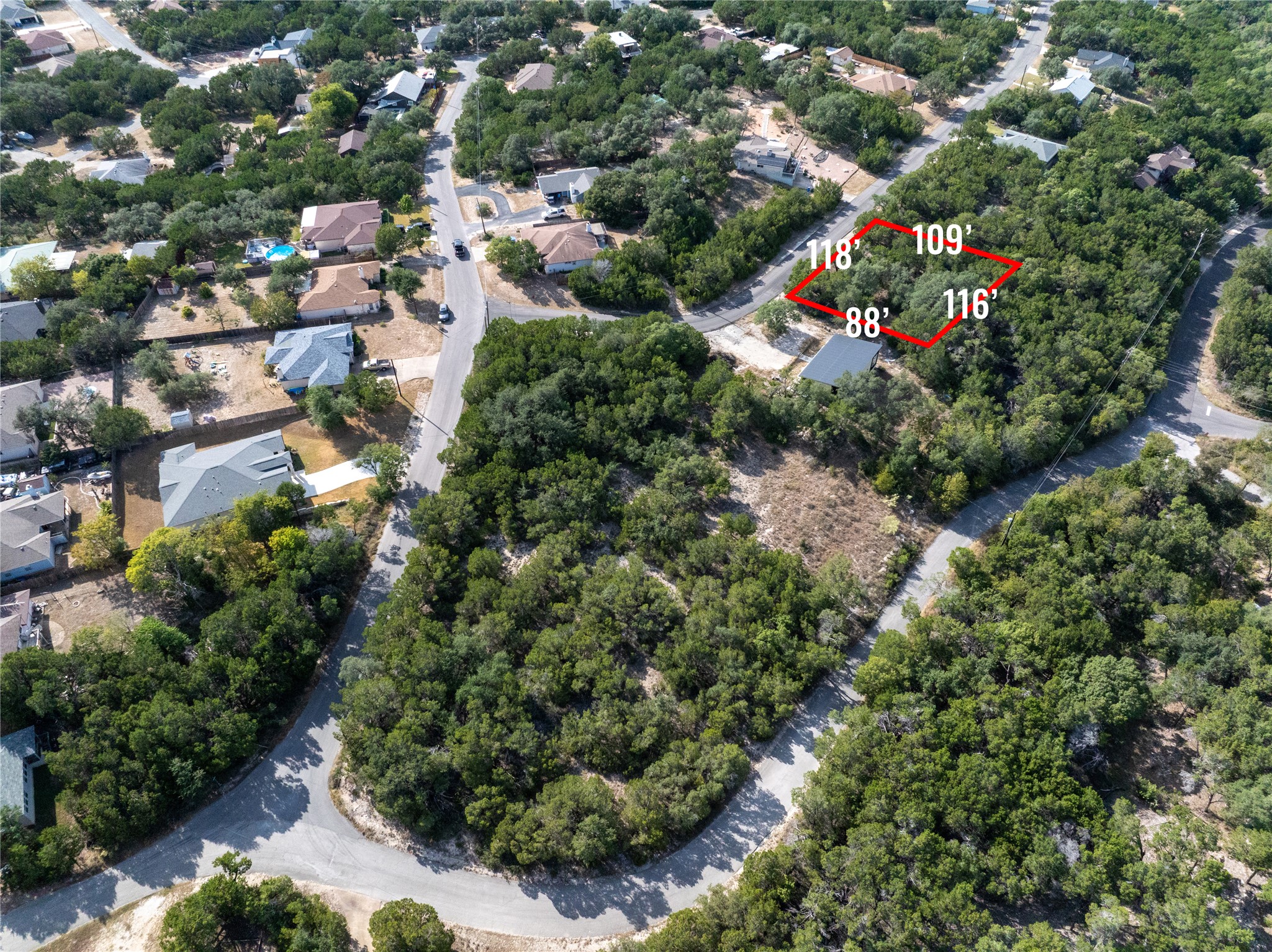 an aerial view of residential houses with outdoor space and trees