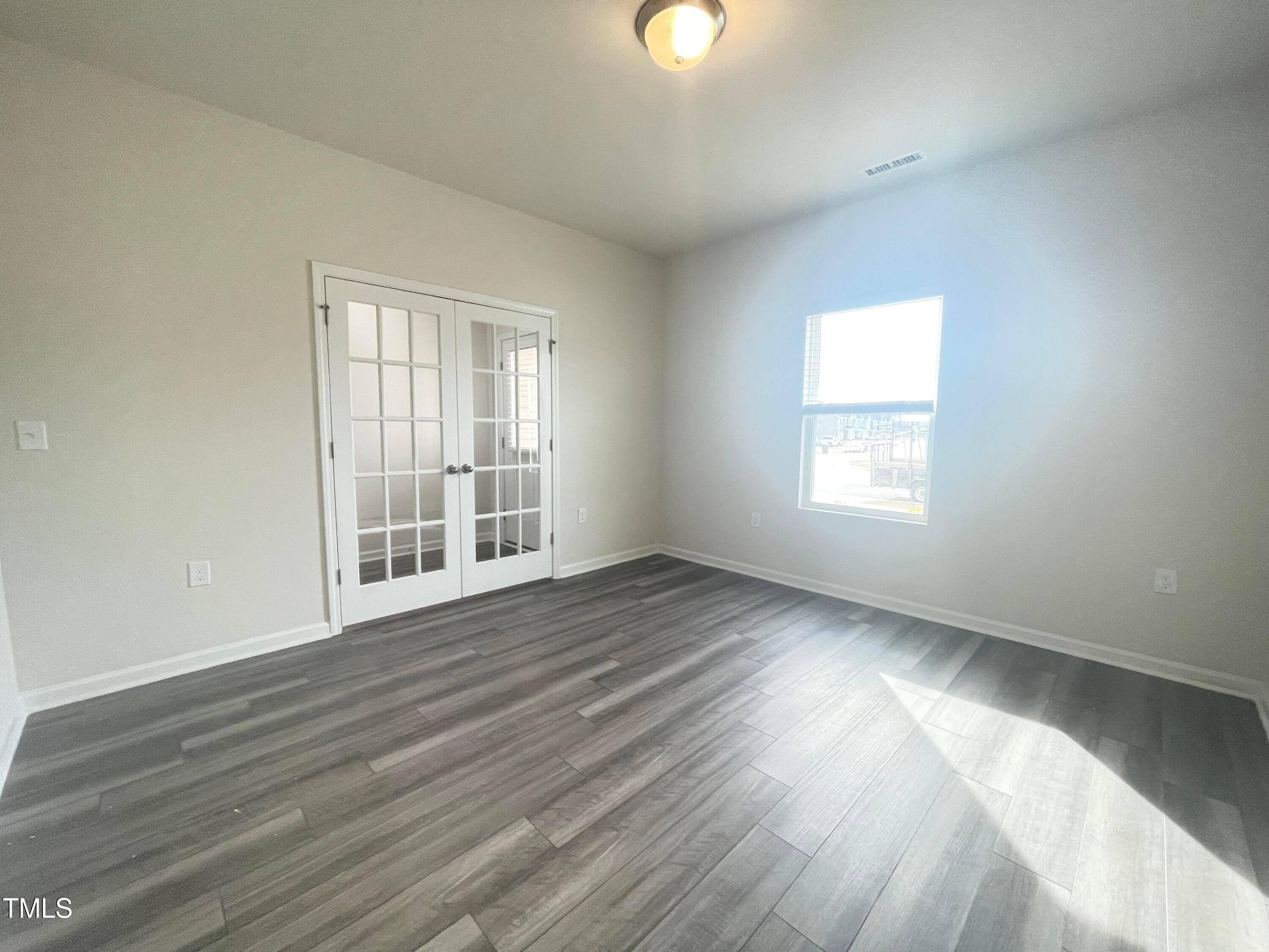 119 Red Valor Street Garner, NC 27529 - Photo 4 of 27 an empty room with wooden floor and windows