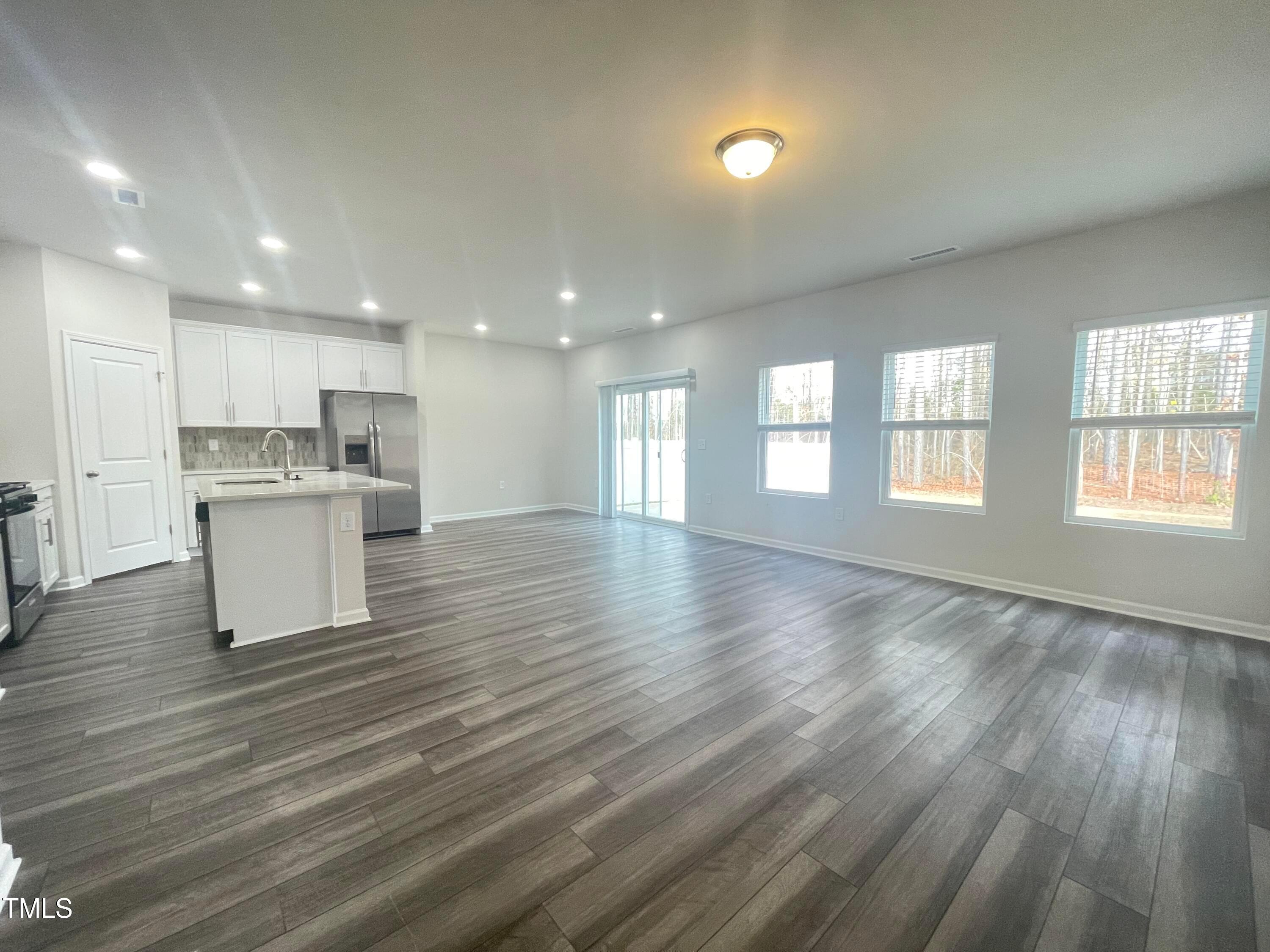 119 Red Valor Street Garner, NC 27529 - Photo 5 of 27 a view of an empty room with wooden floor and a window