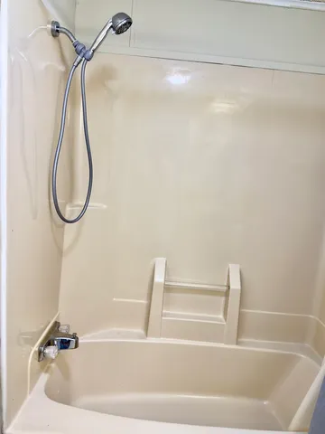 a bathroom with a bath tub with a shower