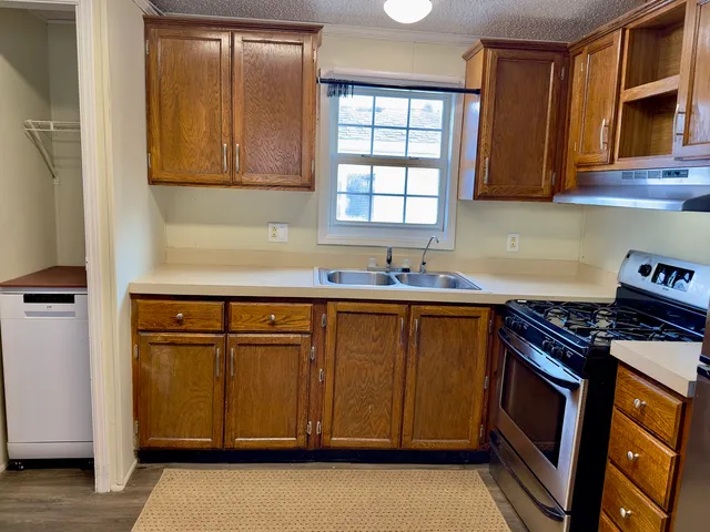 a kitchen with stainless steel appliances granite countertop a stove a sink and a microwave