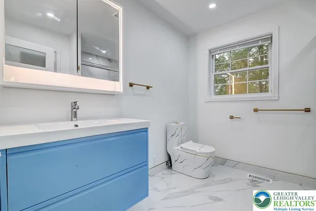 a bathroom with a sink a toilet and a window