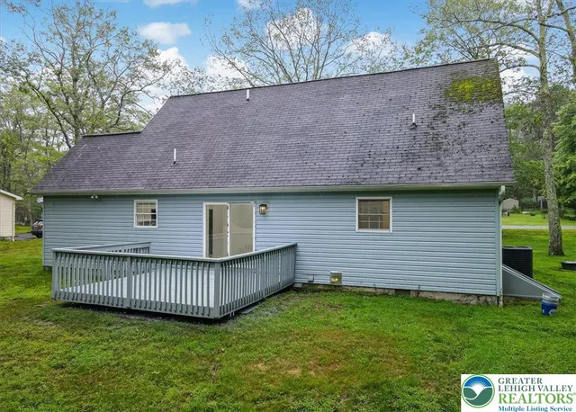 a view of a house with a deck and a yard