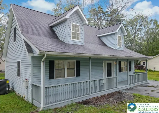 a view of a house with a yard and wooden fence