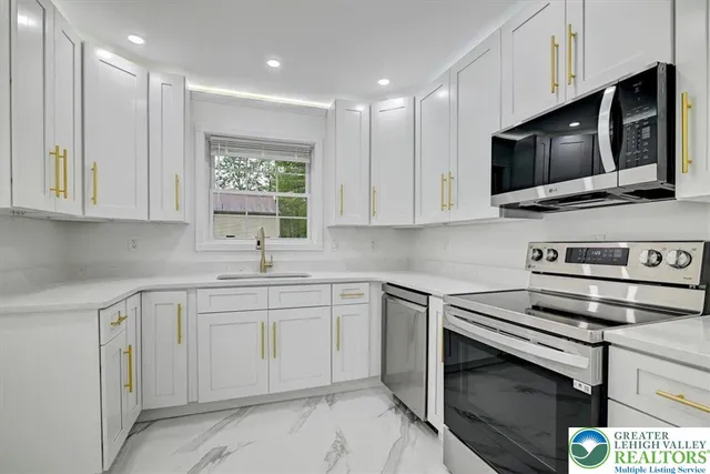 a kitchen with stainless steel appliances a stove microwave and sink