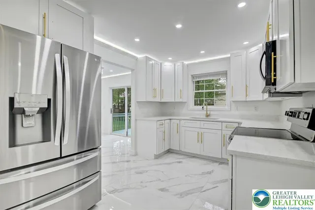 a kitchen with a refrigerator sink and cabinets
