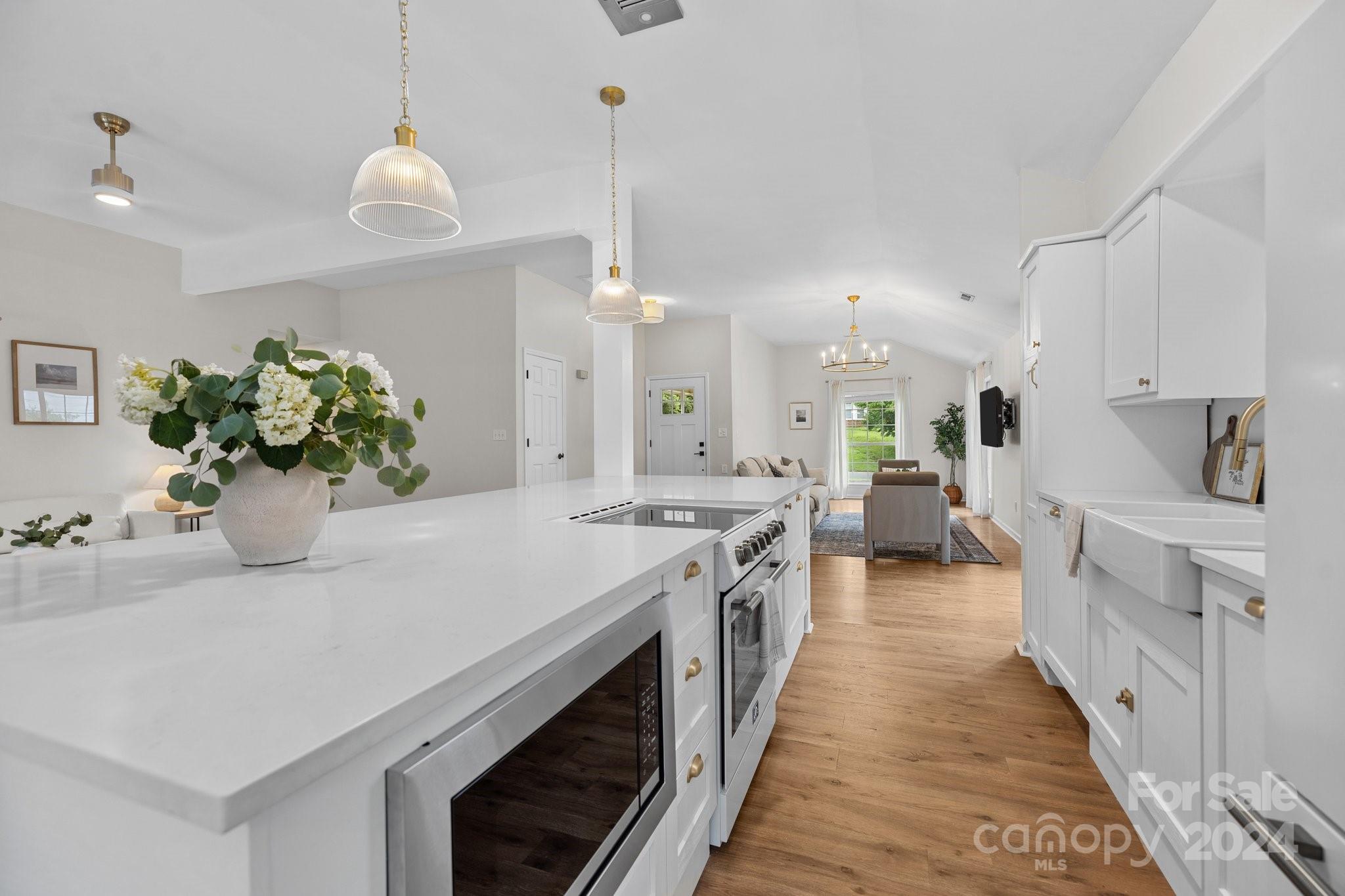 10527 Fairway Ridge Road Charlotte, NC 28277 - Photo 17 of 45 a kitchen with sink stove and white cabinets with wooden floor