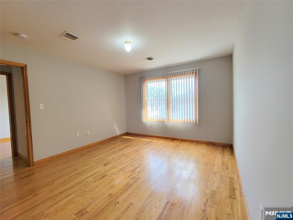 430 Elm Street, Unit 2 Kearny, NJ 07032 - Photo 11 of 14 a view of an empty room with wooden floor and a window