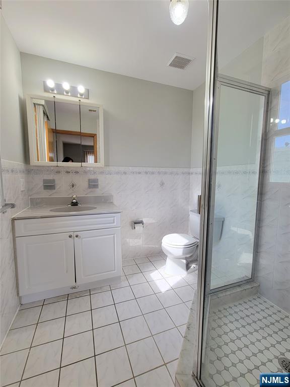 430 Elm Street, Unit 2 Kearny, NJ 07032 - Photo 13 of 14 a bathroom with a double vanity sink mirror and toilet