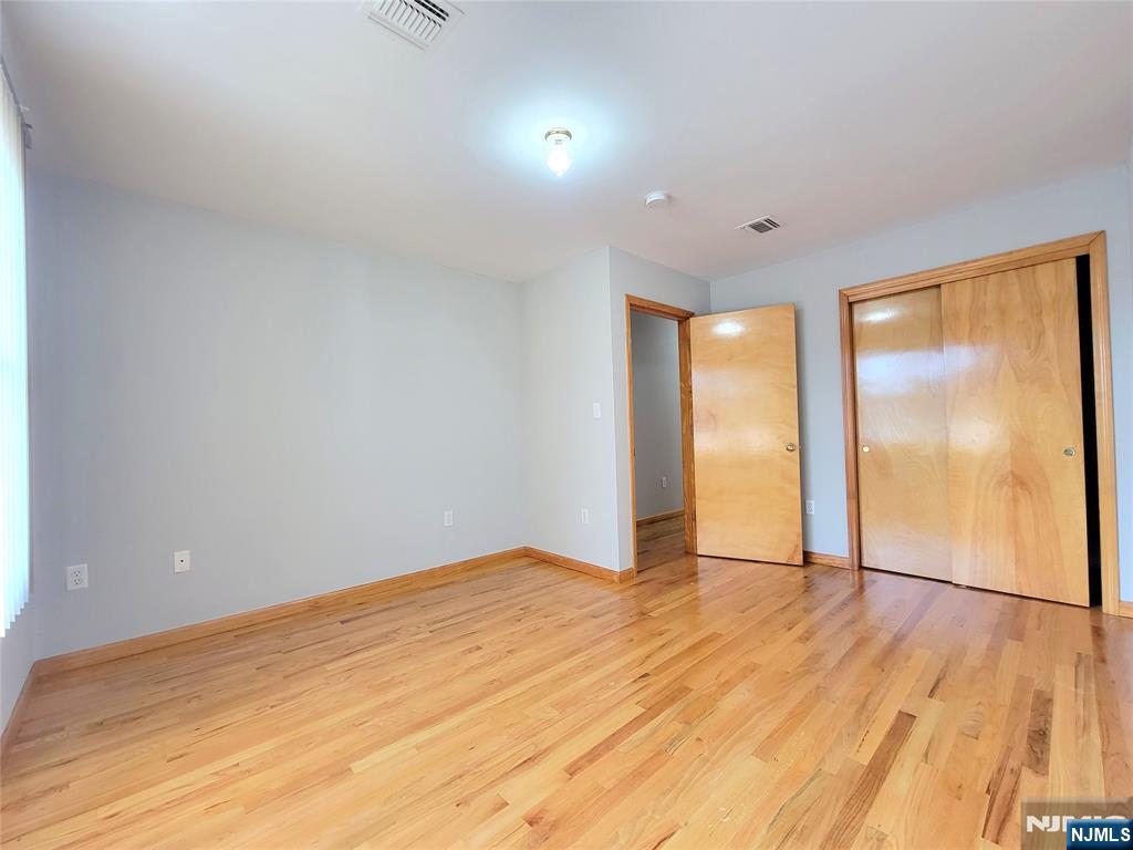 430 Elm Street, Unit 2 Kearny, NJ 07032 - Photo 8 of 14 a view of an empty room with wooden floor and a window