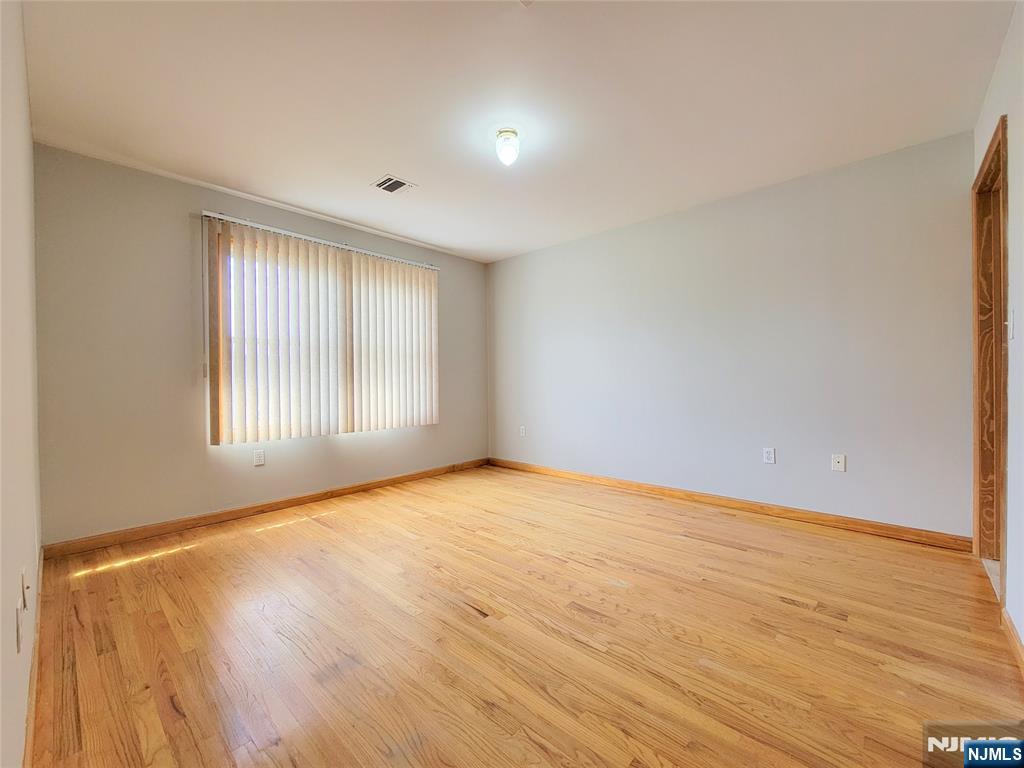 430 Elm Street, Unit 2 Kearny, NJ 07032 - Photo 10 of 14 a view of an empty room with wooden floor and a window