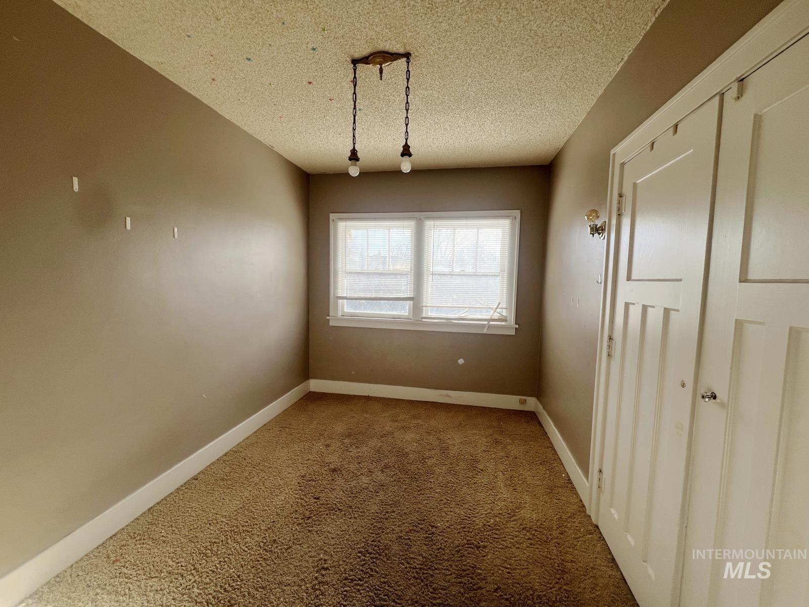 1002 9th Street Clarkston, WA 99403 - Photo 9 of 19 Unfurnished dining area with carpet floors and a textured ceiling