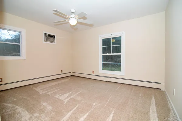 an empty room with windows and fan