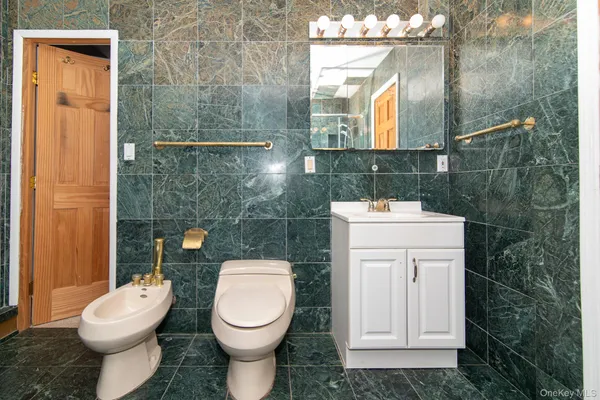 a bathroom with a toilet sink and mirror