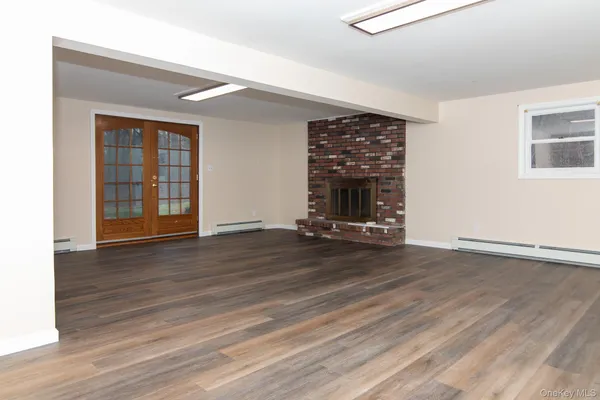 an empty room with wooden floor and a window
