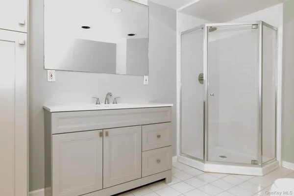 a bathroom with a shower sink and mirror