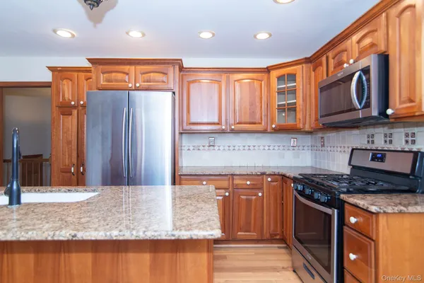 a kitchen with stainless steel appliances granite countertop a stove a sink and a microwave