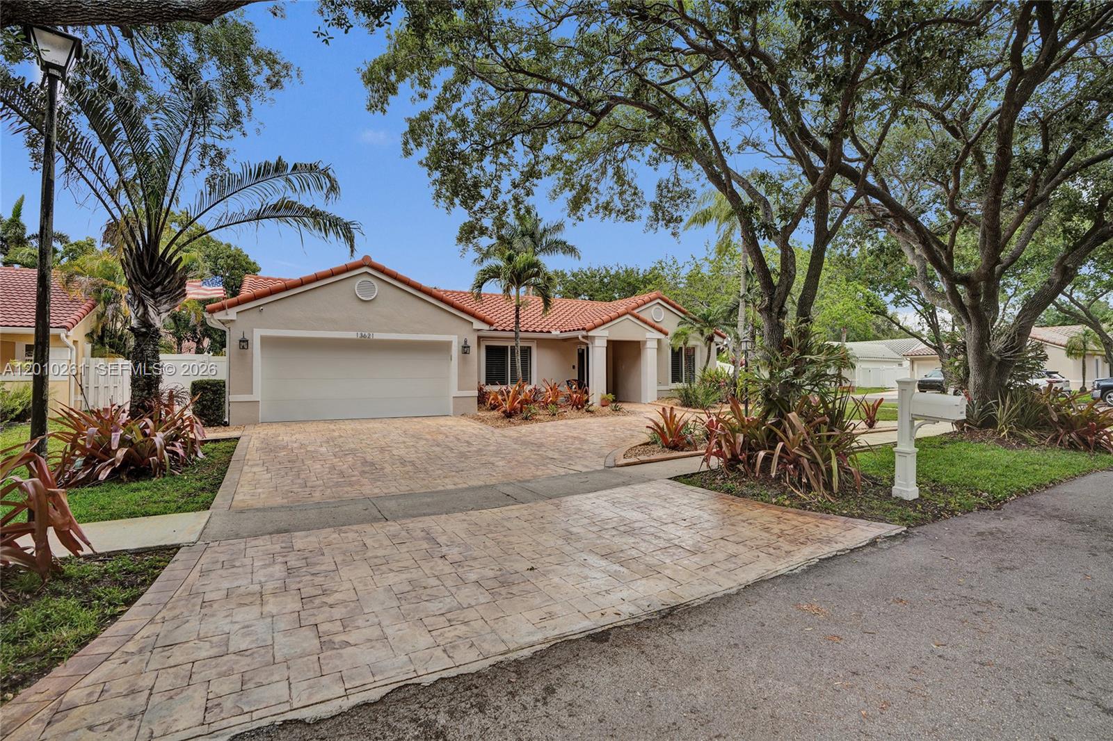 13621 Southwest 18th Street Miramar, FL 33027 - Photo 3 of 45 a front view of a house with a yard and garage