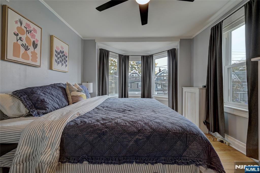 43 Llewellyn Avenue Bloomfield, NJ 07003 - Photo 16 of 25 a spacious bedroom with a large bed and a chandelier