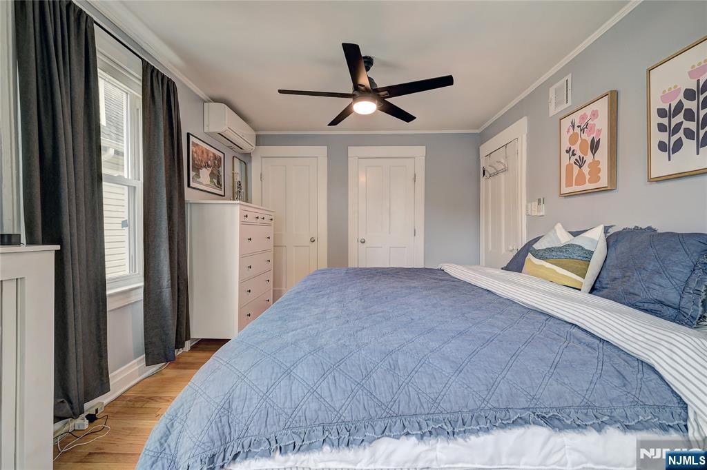 43 Llewellyn Avenue Bloomfield, NJ 07003 - Photo 17 of 25 a spacious bedroom with a bed and painting on the wall