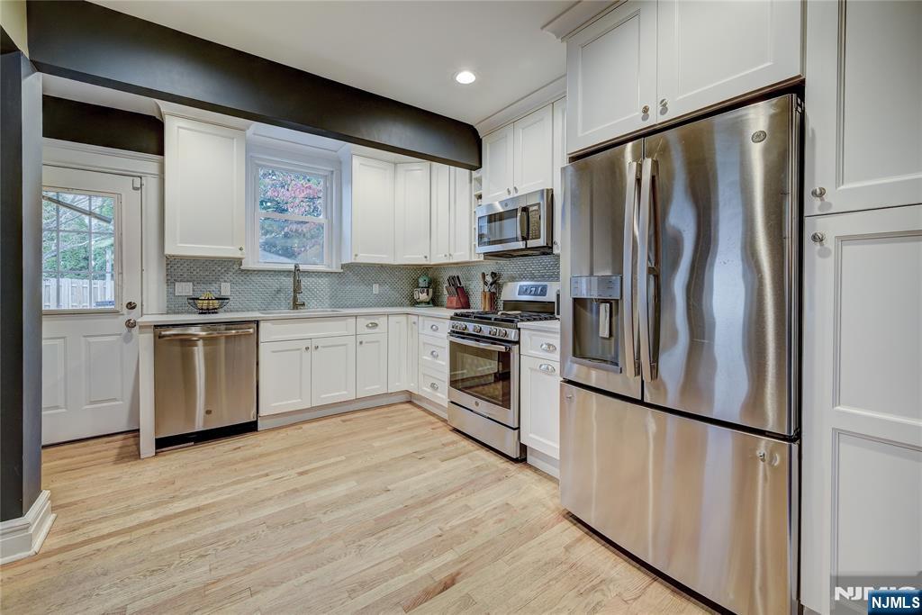 43 Llewellyn Avenue Bloomfield, NJ 07003 - Photo 5 of 25 a kitchen with white cabinets stainless steel appliances and a window