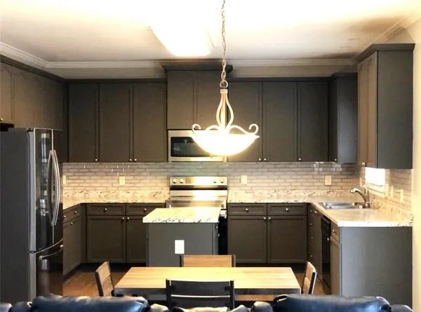 a kitchen with stainless steel appliances kitchen island granite countertop a refrigerator and a stove top oven